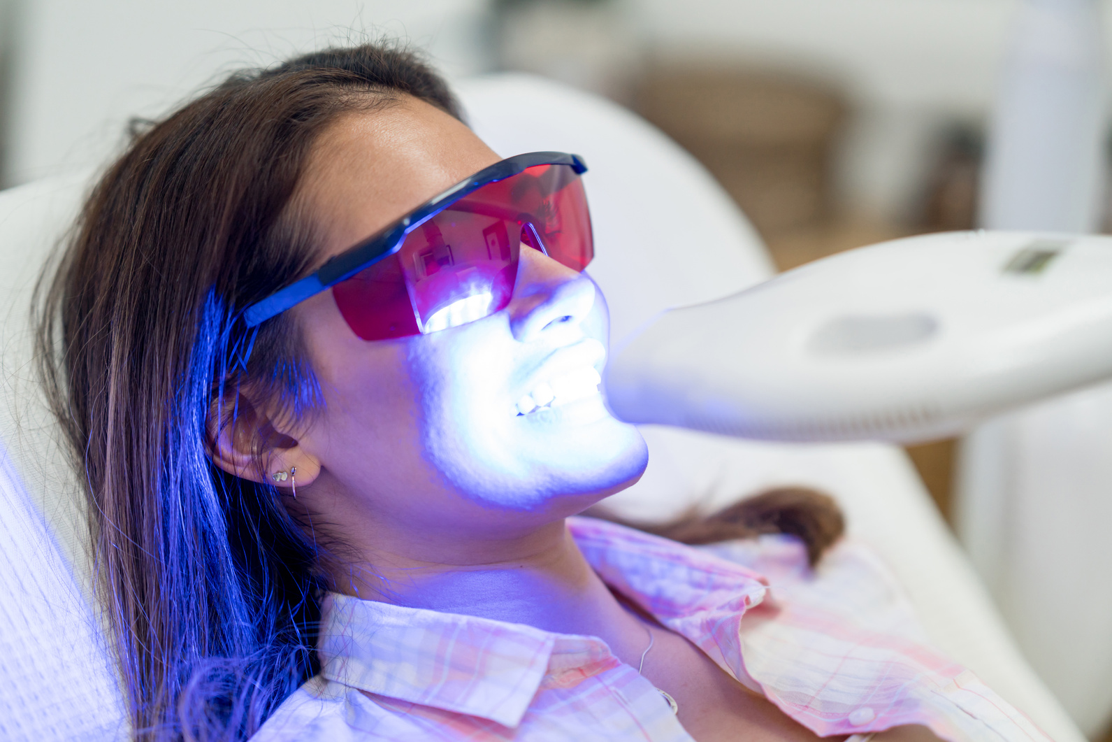 Woman getting laser teeth whitening